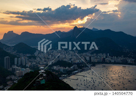 Scenic aerial view of Rio de Janeiro cityscape at sunset with majestic mountains and dramatic cloudy sky over bay Scenic aerial view of Rio de Janeiro cityscape at sunset with majestic mountains and dramatic cloudy sky over bay 140504770