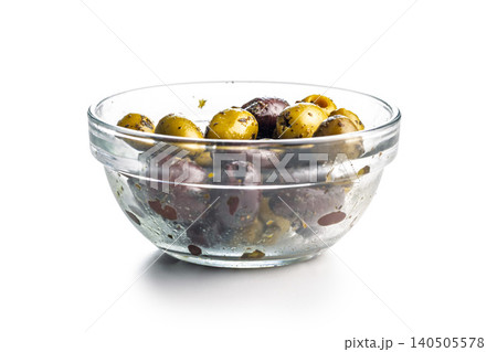 Marinated Mixed Olives In A Glass Bowl Ready As Appetizer Or Mediterranean Snack isolated on white background. Marinated Mixed Olives In A Glass Bowl Ready As Appetizer Or Mediterranean Snack isolated on white background. 140505578