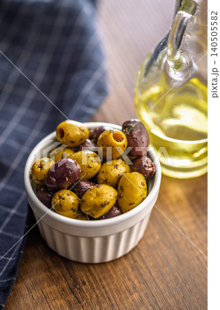 Marinated Green And Kalamata Olives In White Bowl With Olive Oil On Wooden Table Marinated Green And Kalamata Olives In White Bowl With Olive Oil On Wooden Table 140505582