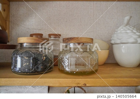 Stylish Kitchen Shelves with Jars Containing Preserves and Unique Decorative Items 140505664