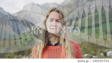 Standing woman wearing orange sweater and shirt in mountain valley with sheer wing overlay Standing woman wearing orange sweater and shirt in mountain valley with sheer wing overlay 140505741