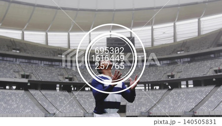 Standing male athlete raising hands in covered stadium, wearing navy-striped kit with HUD numbers Standing male athlete raising hands in covered stadium, wearing navy-striped kit with HUD numbers 140505831