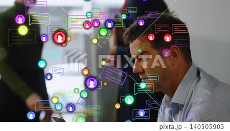 Holding smartphone, man looking down at office desk, light blue shirt, chat icons, copy space 140505903