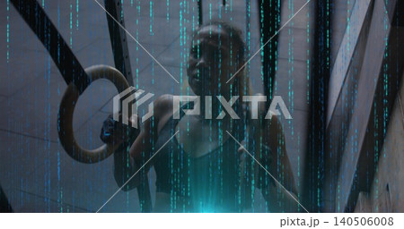 Holding fit woman gripping wooden ring in shaft, wearing dark sports bra, straps and cyan light 140506008