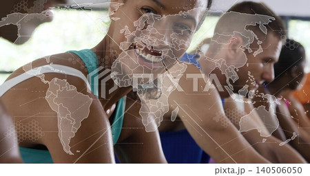 Smiling woman in teal tank leaning on bike handlebars in gym studio, world-map overlay, big windows Smiling woman in teal tank leaning on bike handlebars in gym studio, world-map overlay, big windows 140506050