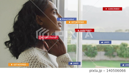 Standing woman touching neck, looking out big window in room in cream sweater, badges, copy space Standing woman touching neck, looking out big window in room in cream sweater, badges, copy space 140506066