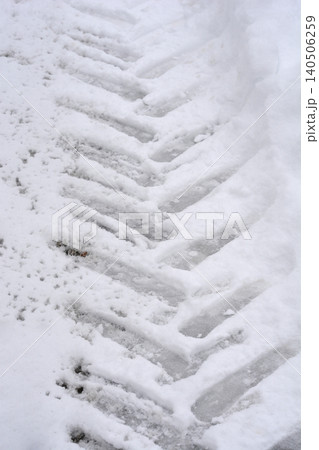 Tractor tire track in fresh snow close up 140506259