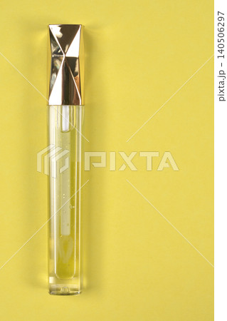 Yellow Lip Gloss Tube on Yellow Background Yellow Lip Gloss Tube on Yellow Background 140506297