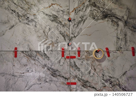 Detailed Close-Up of a Marble Tile Installation with Tape and Markers for Precision Alignment Detailed Close-Up of a Marble Tile Installation with Tape and Markers for Precision Alignment 140506727