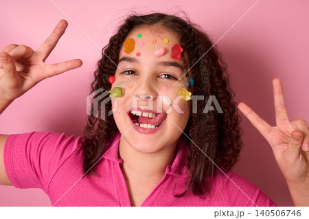 A Joyful Girl Covered in Colorful Candy and Treats with a Fun Pink Background Greeting You A Joyful Girl Covered in Colorful Candy and Treats with a Fun Pink Background Greeting You 140506746