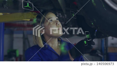 Inspecting mechanic blue-coverall black-gloved under vehicle in workshop with AR overlays, lift arm 140506973