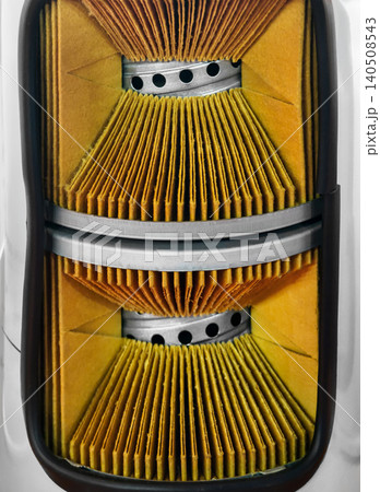 Close look at a car air filter showing detailed layers and design in a workshop setting during afternoon light 140508543