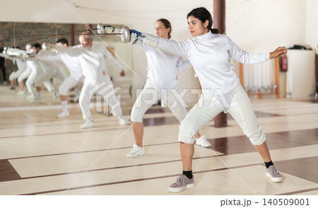 Latina woman in white overalls in fencing club Latina woman in white overalls in fencing club 140509001