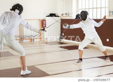 People at a group fencing lesson practice with rapier People at a group fencing lesson practice with rapier 140509077