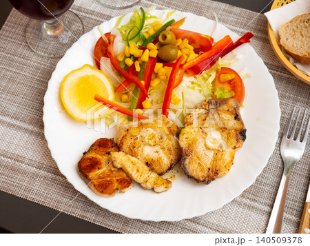 Oven baked hake with vegetable garnish 140509378