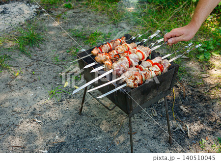 Cooking barbecue with vegetables on skewers. Roasted meat on the grill Cooking barbecue with vegetables on skewers. Roasted meat on the grill 140510045