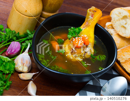 Delicious soup with chicken, bacon, leek and vegetables served in bowl Delicious soup with chicken, bacon, leek and vegetables served in bowl 140510276