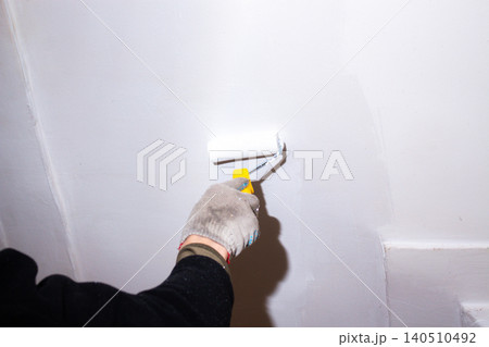 Close up of roller soaking up white paint. DIY approach to home care. Pleasant changes start small. Family budget control through self-repair 140510492