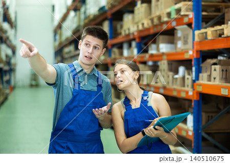 Girl manager and male warehouse worker check the availability of goods on the shelves of hardware store or warehouse Girl manager and male warehouse worker check the availability of goods on the shelves of hardware store or warehouse 140510675