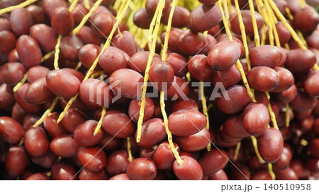 Close-up bunch of fresh ripe dark red date palm fruits Close-up bunch of fresh ripe dark red date palm fruits 140510958