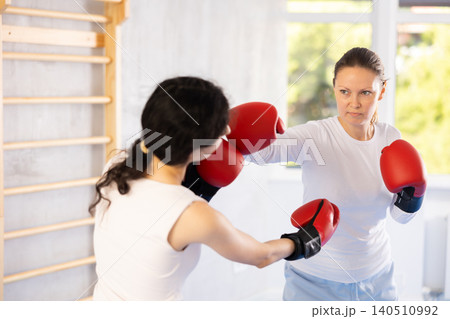 Two women training boxing fight in studio Two women training boxing fight in studio 140510992