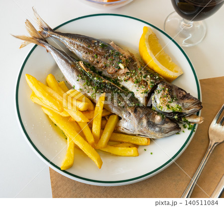 Grilled mackerels with French fries, lemon and sauce Grilled mackerels with French fries, lemon and sauce 140511084