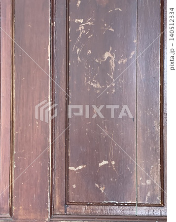 Worn dark wood door texture with visible scratches and aging marks 140512334