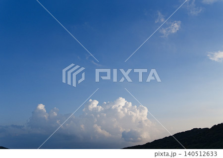 Silhouetted Mountain Ridge Against Vivid Blue Sky at Dusk 140512633