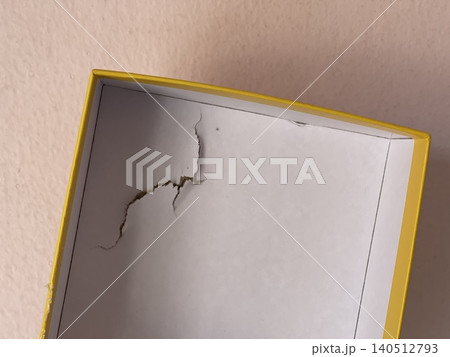 Damaged cardboard puzzle box showing shipping impact and packaging dents Damaged cardboard puzzle box showing shipping impact and packaging dents 140512793