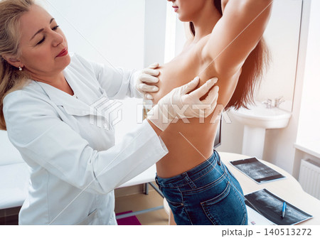Doctor get examining breast of young woman. Consultation with gynecologist. Doctor get examining breast of young woman. Consultation with gynecologist. 140513272