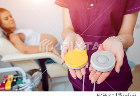 Pregnant woman with electrocardiograph check up for her baby. Fetal heart monitoring Pregnant woman with electrocardiograph check up for her baby. Fetal heart monitoring 140513313