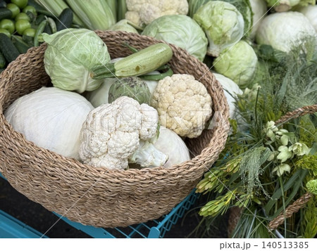 Basket filled with fresh cabbage, cauliflower, and zucchini at a farmers market stall Basket filled with fresh cabbage, cauliflower, and zucchini at a farmers market stall 140513385