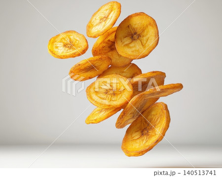 Crispy Golden Fried Banana Chips Falling in the Air Isolated on Neutral Background Crispy Golden Fried Banana Chips Falling in the Air Isolated on Neutral Background 140513741
