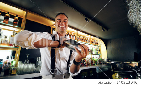 Professional bartender smiling shaking cocktail at modern bar 140513946