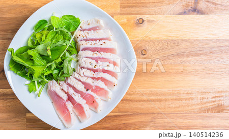 レアに仕上げたマグロステーキとベビーリーフの盛り付け 140514236