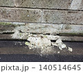経年劣化によりボロボロに剥離して破片が落ちた大谷石のブロック塀 140514645