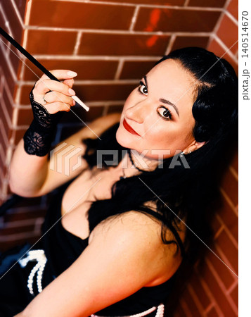 Stylish woman holding cigarette holder portraying retro glamour 140514670