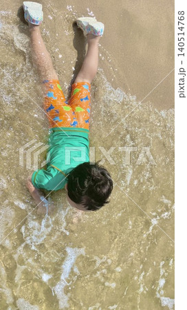 波打ち際で遊ぶラッシュガード姿の子どもを上から撮影した夏の海（縦長） 140514768