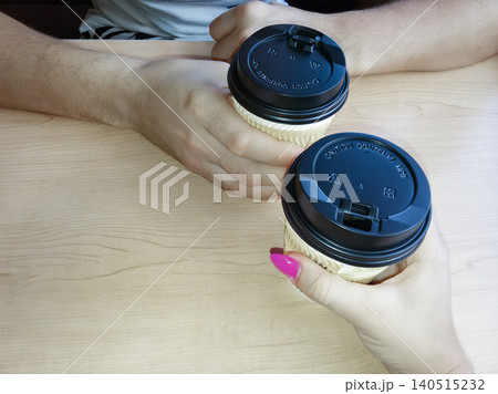 Couples coffee break with two paper cups in hands, morning date concept. Couples coffee break with two paper cups in hands, morning date concept. 140515232