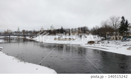 Winter cityscape with a river and orthodox cathedrals under a cloudy sky. 140515242