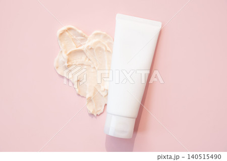 White tube with cosmetic cream and smear on pink background. Skincare product for face or body care routine. Beauty treatment, spa and dermatological supply for moisturizing procedure. 140515490