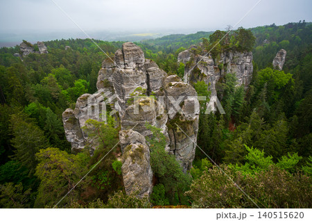 Rock city formations in Hruboskalsko, Bohemian Paradise (Cesky raj), Czech Republic, with peaks of giant sandstone rocks and cliffs emerging from light morning mist panoramic view Rock city formations in Hruboskalsko, Bohemian Paradise (Cesky raj), Czech Republic, with peaks of giant sandstone rocks and cliffs emerging from light morning mist panoramic view 140515620