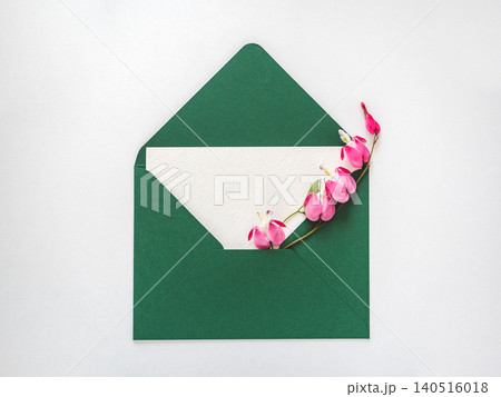 Postal envelope, white card and fresh flowers Postal envelope, white card and fresh flowers 140516018