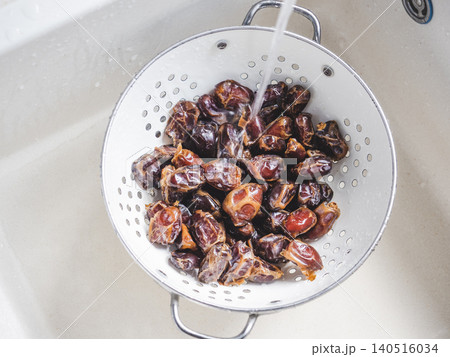 Dried brown dates in a colander 140516034