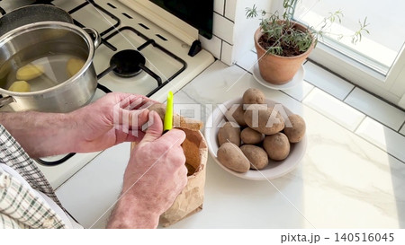 Man peels a potato Man peels a potato 140516045