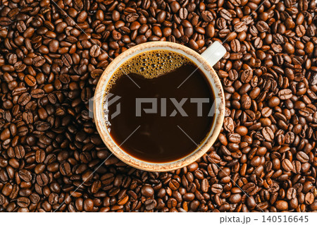 Cup of black coffee on roasted coffee beans background, top view Cup of black coffee on roasted coffee beans background, top view 140516645