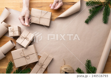 Woman Tying Twine Around Christmas Gift Box Woman Tying Twine Around Christmas Gift Box 140516793