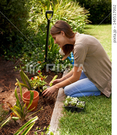 Woman, flowers and gardening for agriculture in backyard with garden shovel, happiness and sustainability. Gardener, person and green fingers with plants and soil for growth or eco friendly hobby Woman, flowers and gardening for agriculture in backyard with garden shovel, happiness and sustainability. Gardener, person and green fingers with plants and soil for growth or eco friendly hobby 140517002