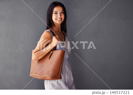 Studio, portrait and handbag with fashion, joy and accessories with dress and smile. Woman, face and model with confidence, beauty and happiness with purse and style isolated on gray wall background 140517221