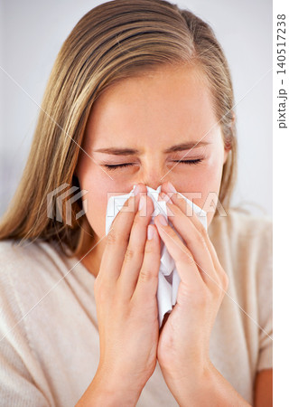 Woman, sneeze and sick with flu or allergies and blowing nose in tissue for healthcare and healing in home. Medical, burnout and care for virus infection or person with sinusitis in apartment 140517238